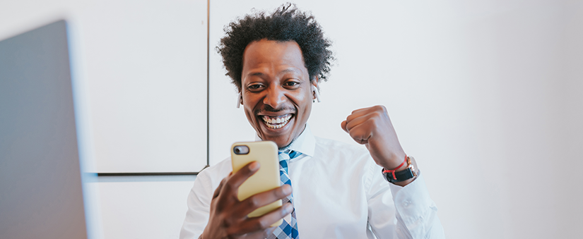Novo Portal do Cliente: empresário comemora enquanto olha para o celular