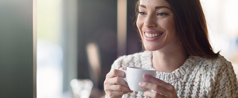 Marketing de Experiência: mulher sorri segurando xícara