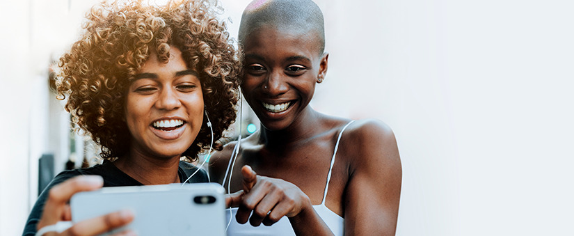 Redes sociais do corretor de imóveis: garotas sorriem olhando para celular