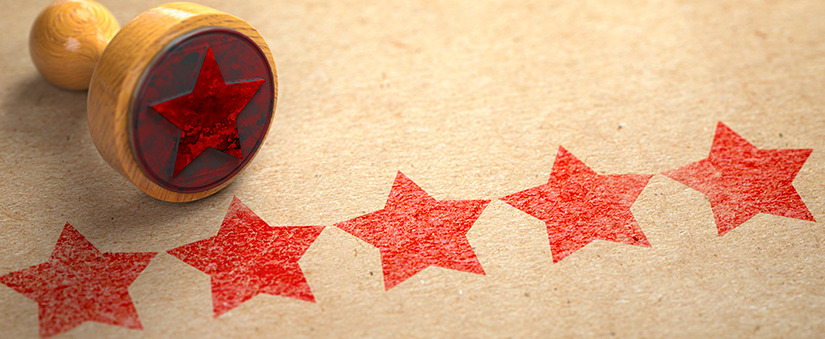 Customer Success: cinco estrelas vermelhas carimbadas em papel castanho com carimbo deitado ao lado
