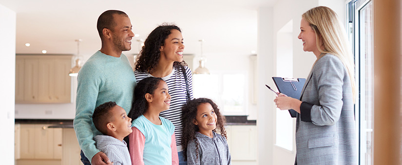 Corretora de imóveis mostrando família interessado em comprar em torno de casa