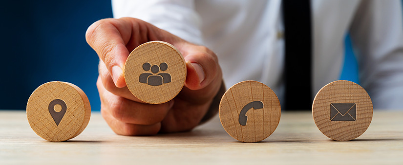 4 círculos de madeira com ícones que representam localização, interação, ligação e e-mail. 