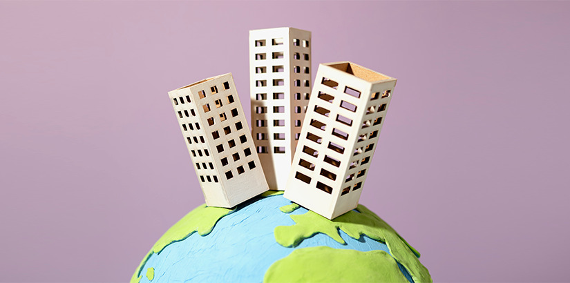 práticas sustentáveis: ilustração de prédios no topo de uma miniatura do planeta terra