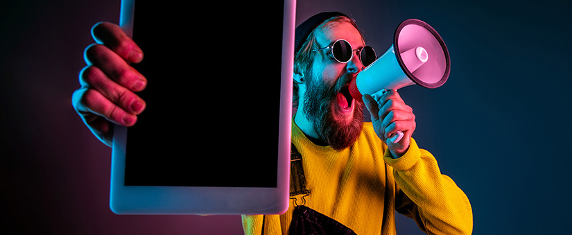 reduzir custos: imagem de um homem gritando num megafone, segurando um tablet em frente à câmera