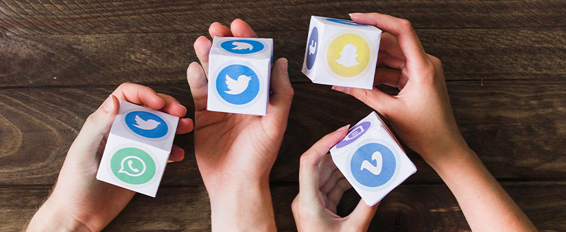 coleta de dados: imagem de mãos de duas pessoas segurando cubos com ícones de redes sociais.