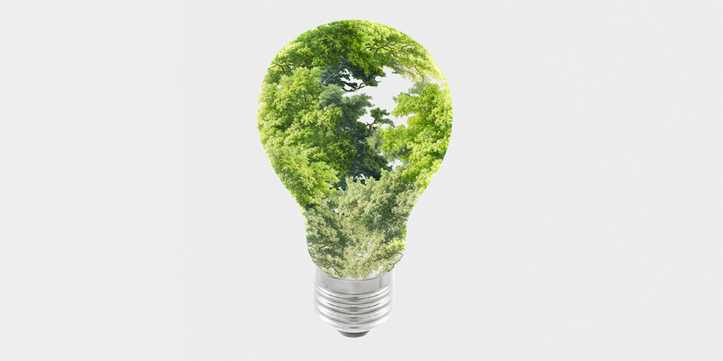 casa sustentável: imagem de uma lâmpada com algumas árvores dentro, formando a silhueta da lâmpada.