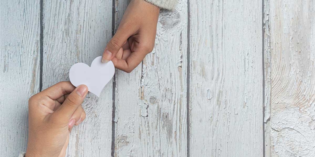 Captar novos clientes: imagem de duas mãos segurando um coração de papel.