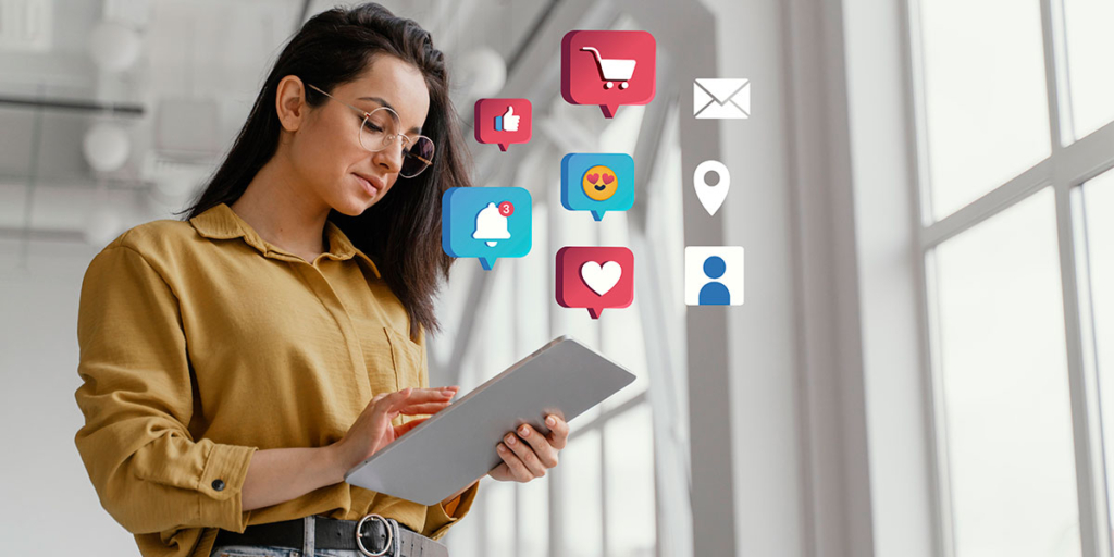 Dicas para corretor de imóveis iniciante: mulher segurando um tablet. Em destaque, acima do tablet, alguns ícones de redes sociais.