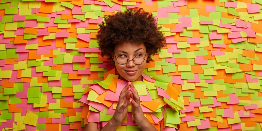 marketing sensorial: imagem de uma mulher encostada numa parede com vários papeis coloridos grudados.