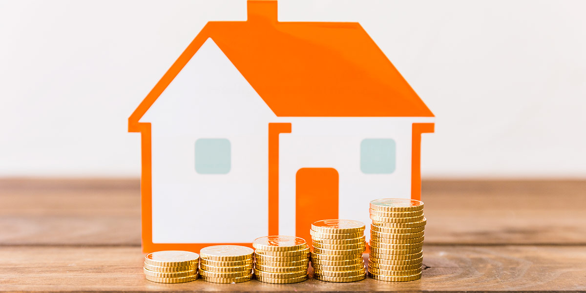O que é lig investimento: ilustração de uma casa e algumas moedas empilhadas na frente.