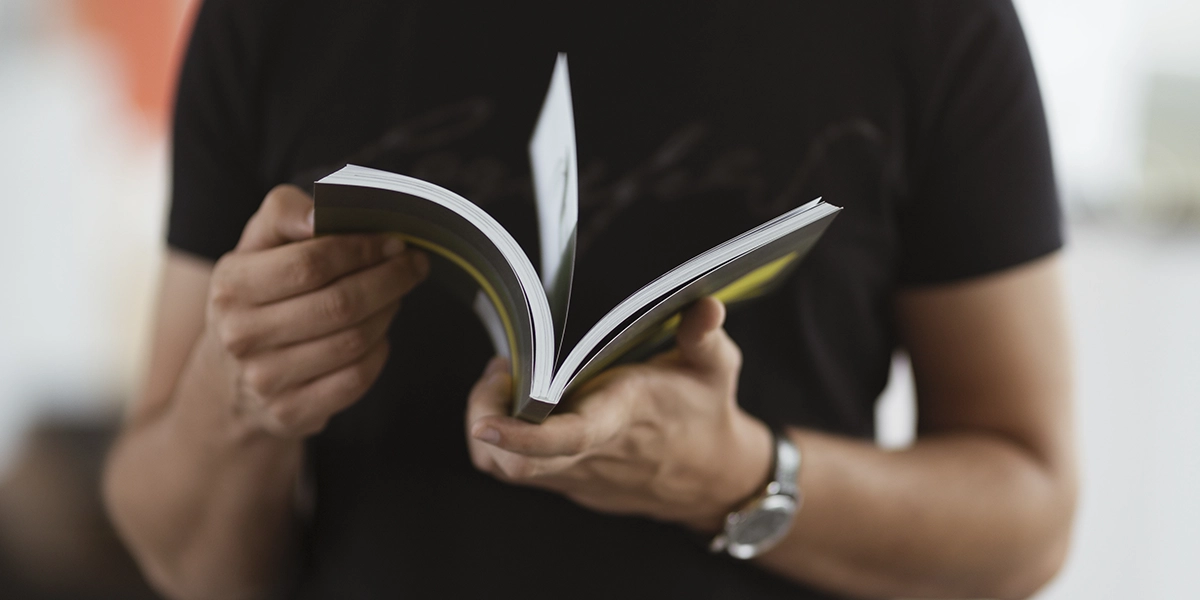 Manual do Proprietario: close nas mãos de uma pessoa folheando um livro