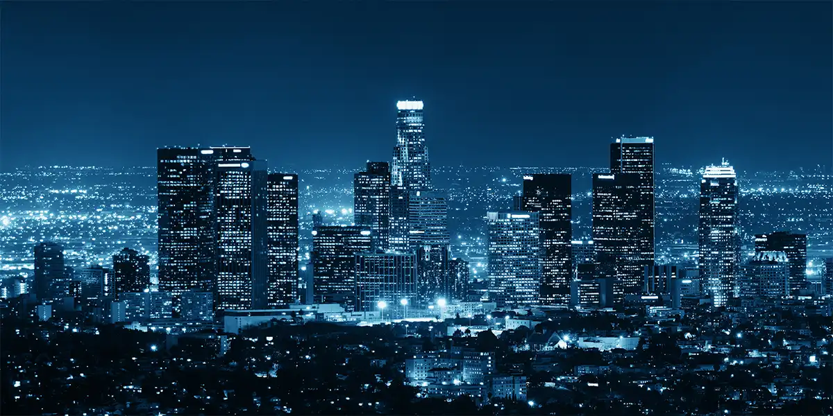 Infraestrutura Urbana: imagem de uma cidade de noite, com muitos edifícios e luzes azuis.