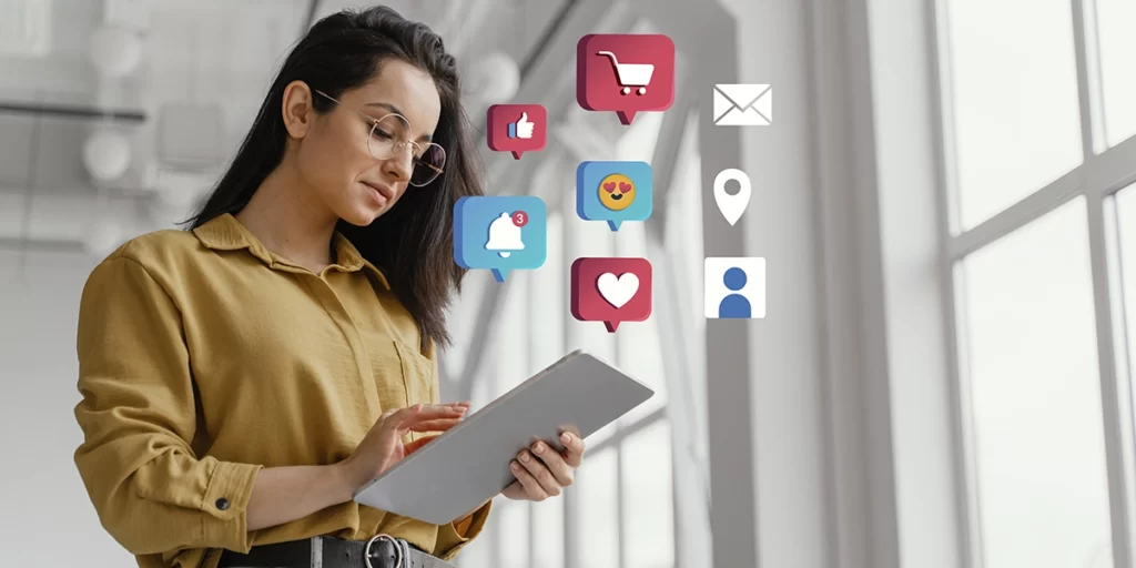 Anúncio Imobiliário: imagem de uma mulher segurando um tablet. Da tela saem alguns ícones que representam compras, interação social, e-mail, notificação, etc.