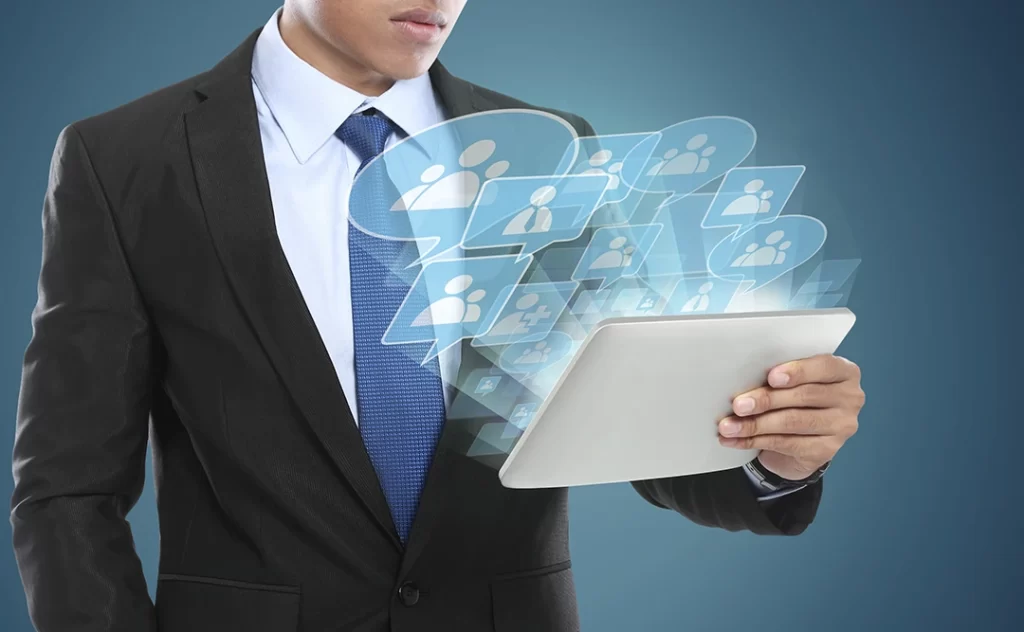 Como prospectar mais clientes: imagem de fundo azul de um homem de terno segurando um tablet. Da tela saem ícones de balões de fala e pessoas.