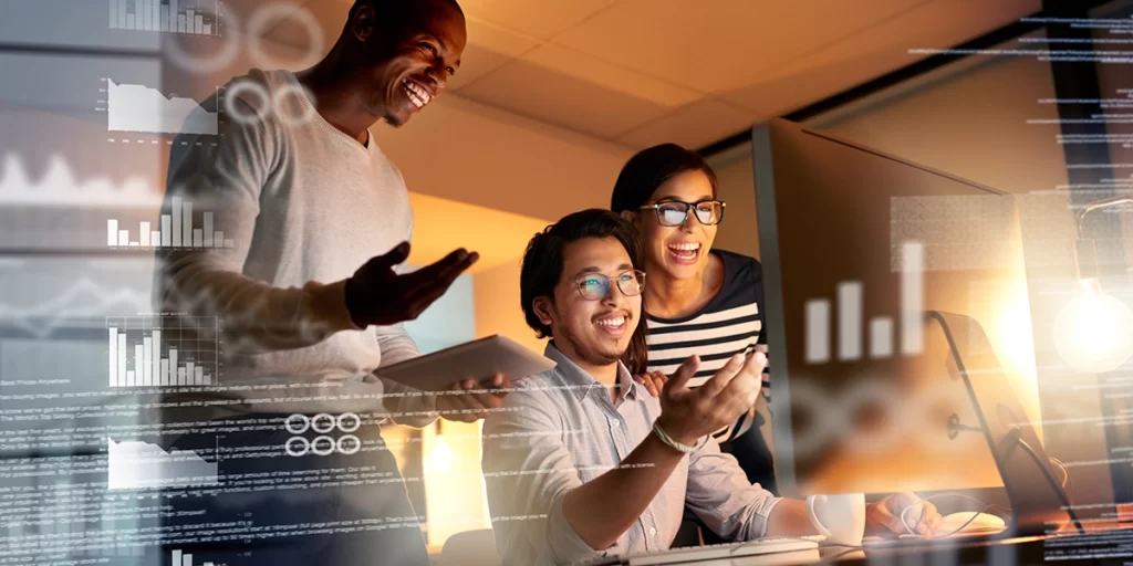 Software Imobiliário: imagem de três pessoas sorrindo, olhando para a tela de um computador.

