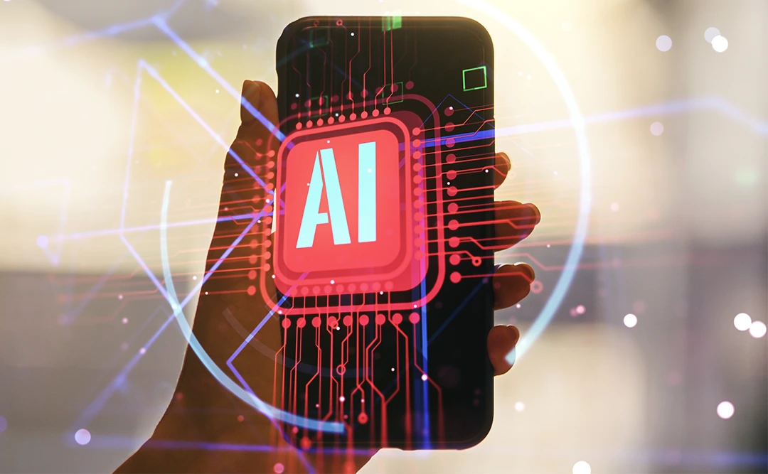 vantagens da inteligência artificial: imagem de uma mão segurando um celular. No centro uma ilustração com a sigla "AI"