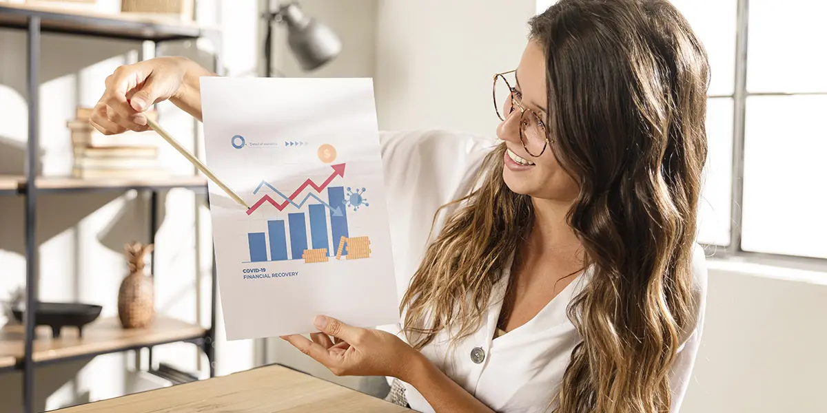 leads de loteadoras: imagem de uma mulher segurando um papel com um gráfico de barras crescente.