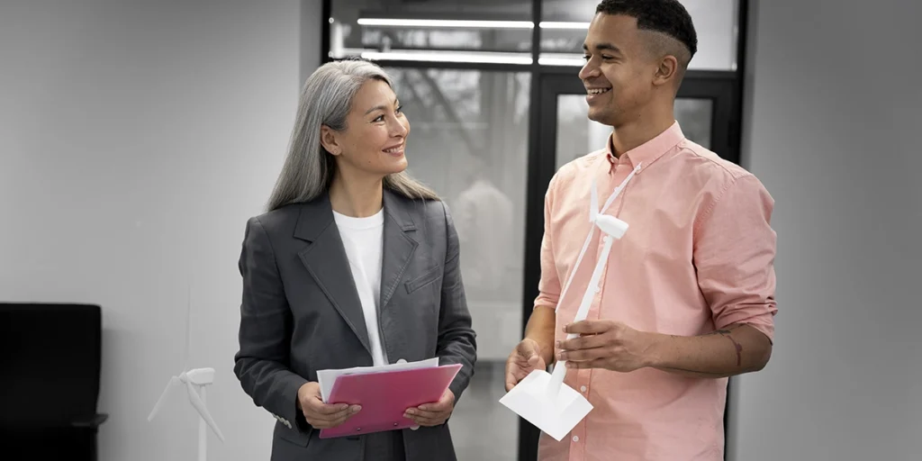 Na foto, uma mulher e um homem olhando um para o outro em ambiente de trabalho. 