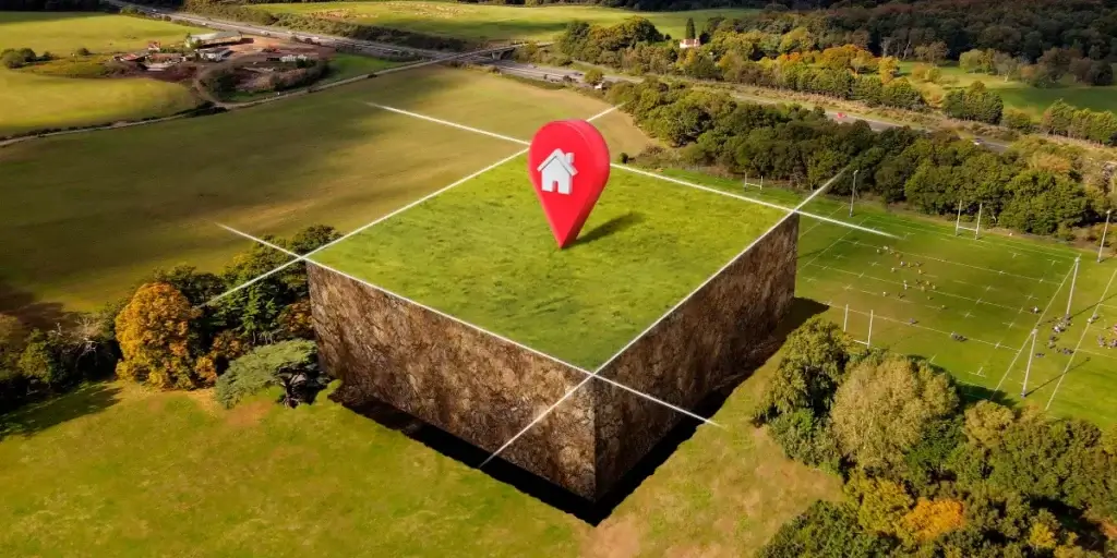 Licenciamento ambiental para loteadoras: Imagem mostra um terreno com grama e uma vegetação ao redor. No centro da imagem, há um destaque em 3D com um símbolo de localização. 