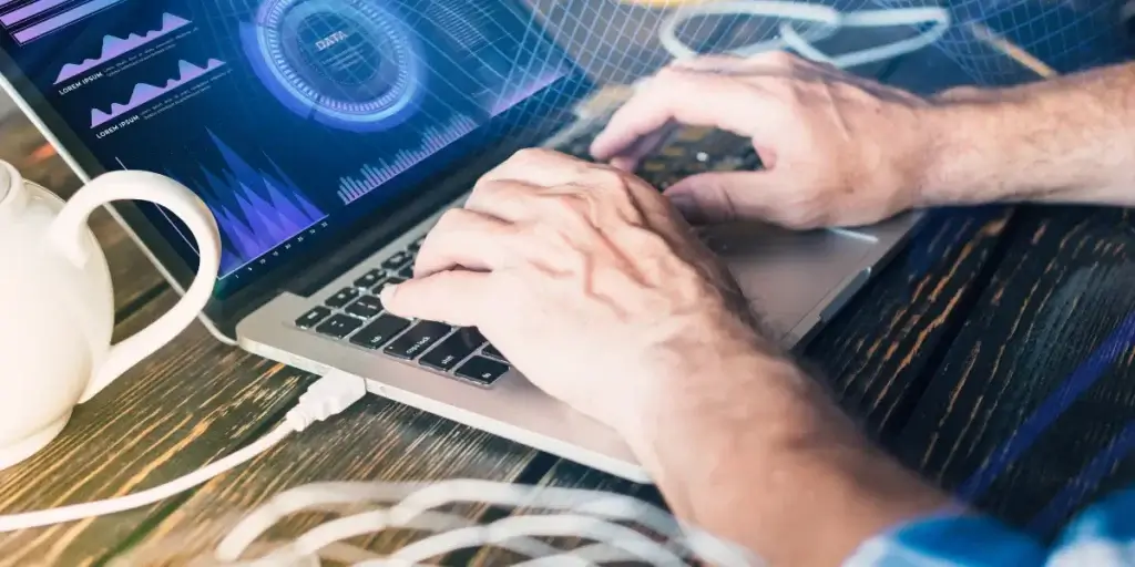 integração de processos para incorporadoras: imagem de mãos digitando num notebook com alguns gráficos na tela.