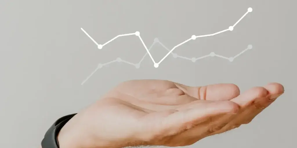 CRM para equipe de vendas imobiliárias CRM para equipe de vendas imobiliárias: imagem de uma mão aberta. Em cima da mão linhas de gráfico.