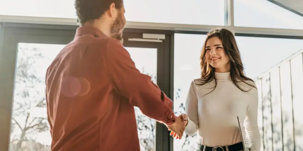 parceria imobiliária parceria imobiliária: imagem mostra um homem e uma mulher dando as mãos, um de frente para o outro.