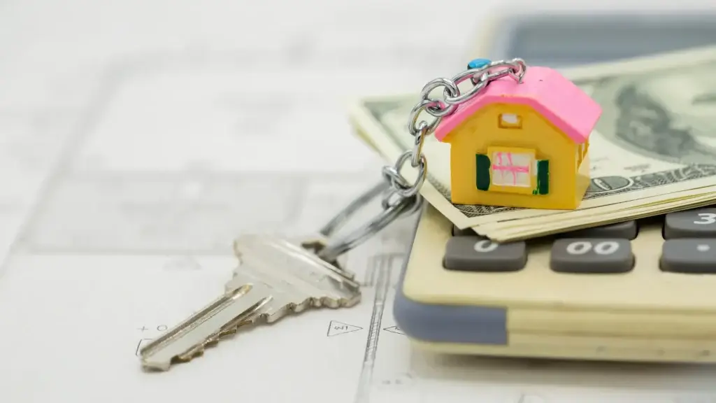 gestão de carteira imobiliária gestão de carteira imobiliária: imagem mostra parte de uma calculadora, em cima de alguns projetos arquitetônicos. Há uma quantidade de dinheiro por cima do equipamento, com um chaveiro em forma de casa em cima, e a chave pendurada.